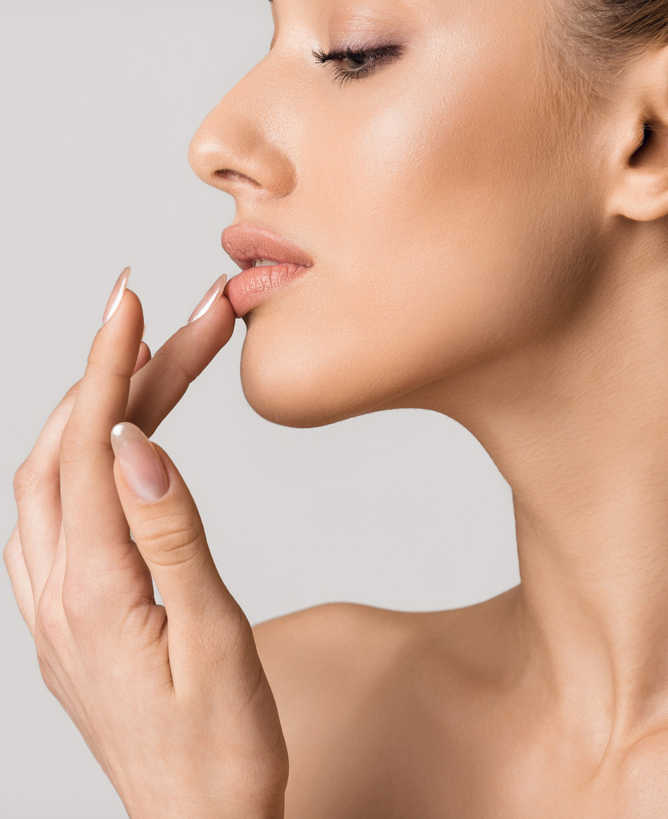 Side-profile-photo-of-woman-touching-her-lips-injected-with-lip-fillers