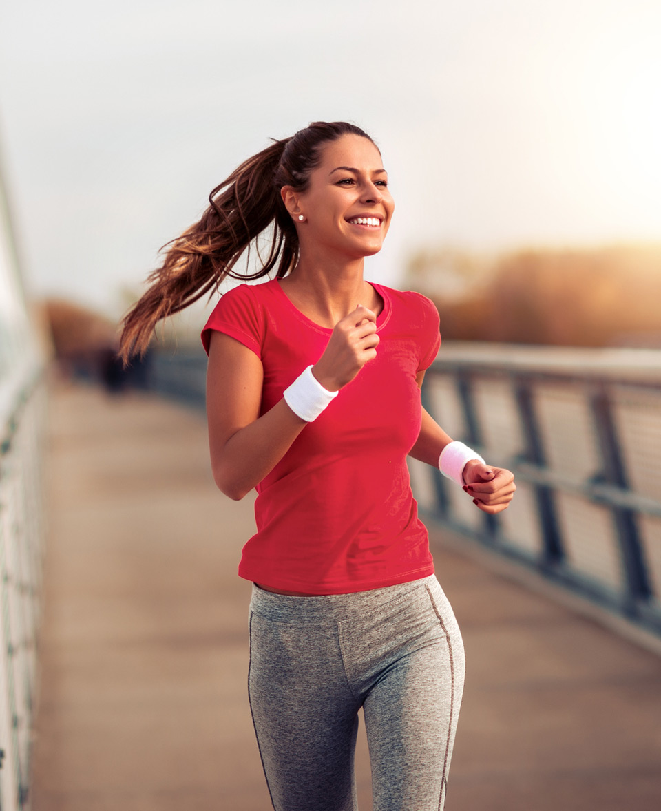 Woman-running-outdoors-across-a-bridge-after-successful-CoolSculpting-treatment