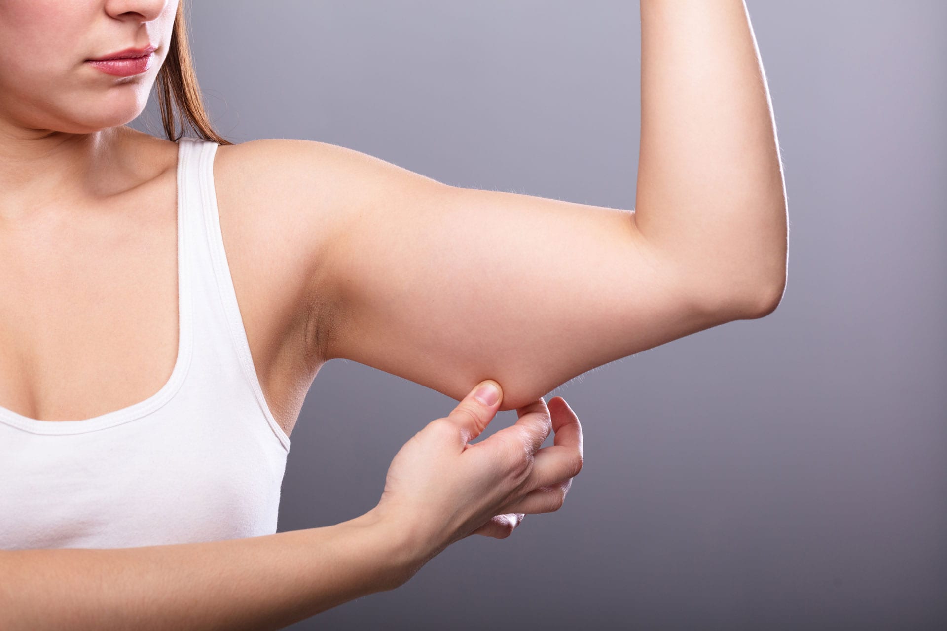close-up-of-a-woman-holding-arm-with-excess-fat-and-needing-coolsculpting