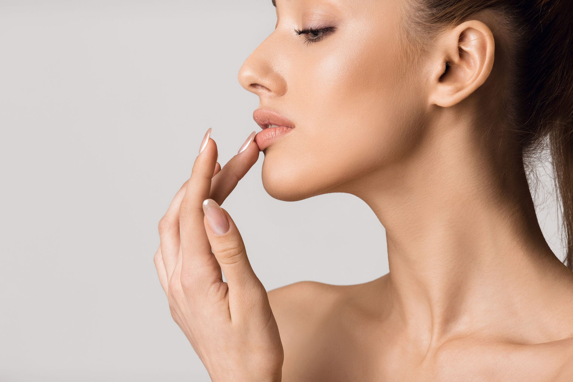 side-profile-photo-of-woman-touching-her-lips-injected-with-lip-fillers