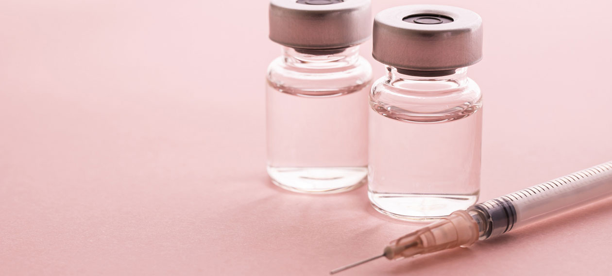 two-medication-vials-and-a-syringe-on-a-pink-background
